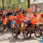 Kinderen versieren hun fietsen op Koningsdag.