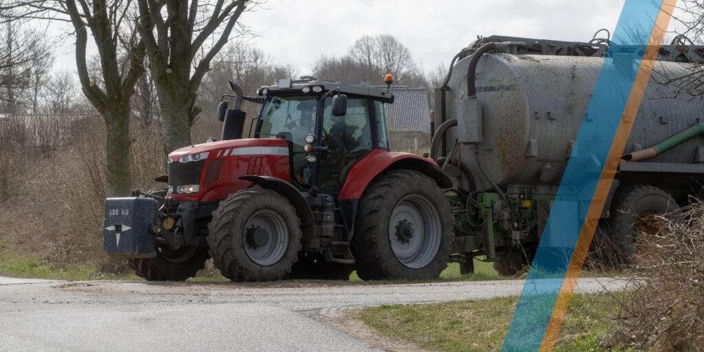 Boer rijdt een tractor met mest.